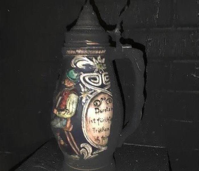 family urn damaged by fire sitting on a mantle