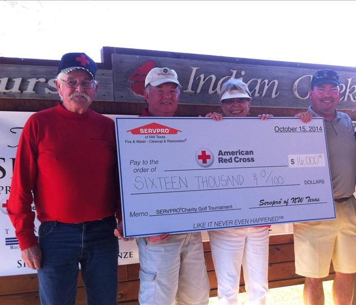 SERVPRO owners holding a check for the American Red Cross