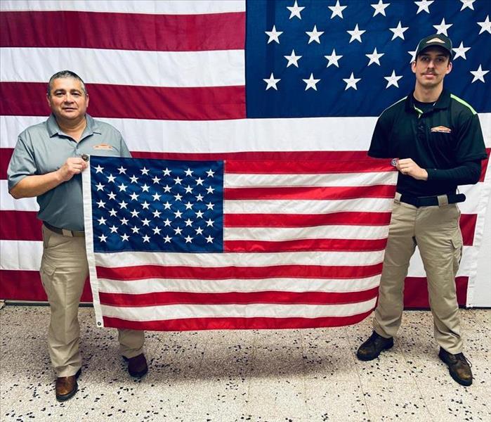 two men holding an american flag against an american flag background