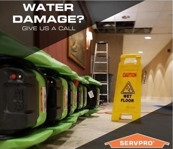 green and black air movers on a tile floor next to a yellow wet floor sign